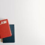 Flat lay of a red law book and a blue book on a white background, perfect for legal themes.